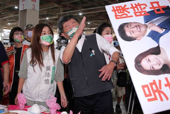 陈时中(左3)与吴沛忆(左2)拜票时，遭自家人持看板戳中嘴巴，本能地用手拨开。（资料照／黄世麒摄）