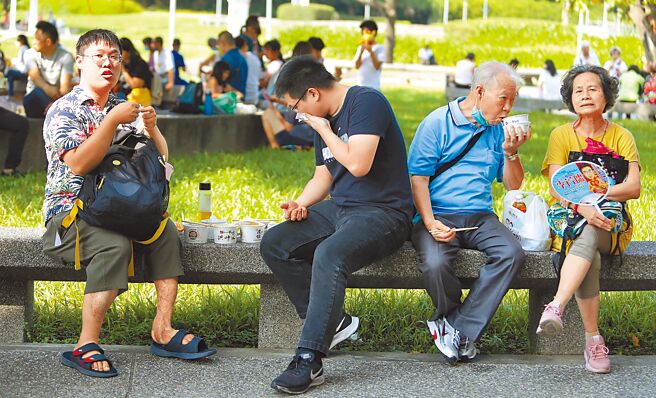 中央流行疫情指挥中心17日公布国内新增39394例本土个案及234例境外移入，图为假日外出游玩民眾，拿下口罩吃东西。（季志翔摄）