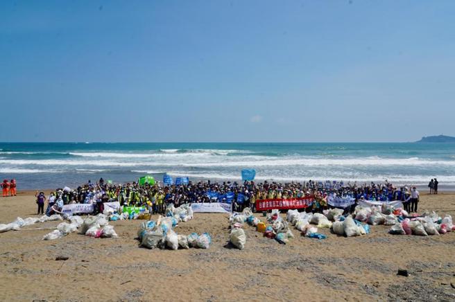 （光寶科技、仁寶科技、研華科技、三星電子、南亞科技與南亞塑膠等六大企業於917國際淨灘日聯合淨灘，並將淨灘撿拾的廢棄物排列為各企業字母(ACLNNS)開頭，期許更多人一起為海洋挺身而出。圖／光寶科提供）