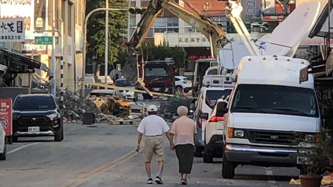 一名网友在网路上传暖心照片，照片中一对老夫妇牵着彼此的手，朝塌楼方向走去，引发超过3千多网友留言按讚。（图／翻摄自爆废公社公开版）