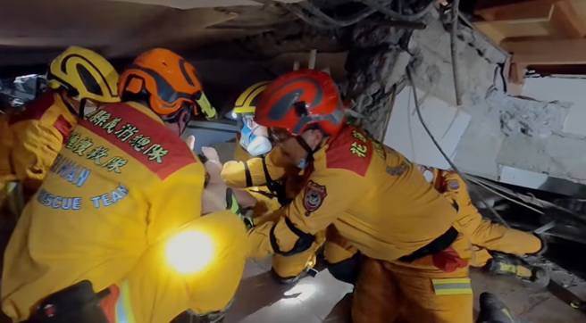 救難人員冒著餘震不斷的危險，進入倒塌的樓層，安撫哭喊尖叫的小女孩，且順利將她救出。（消防攝手 蔡哲文授權提供）