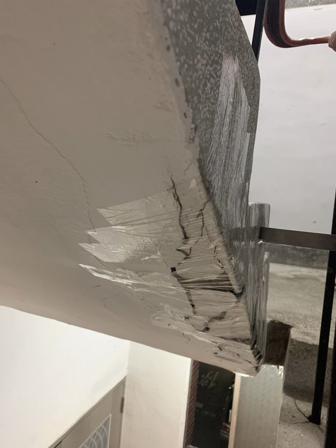 一名网友住家楼梯间出现大片裂痕，邻居拿出胶带固定。(翻摄自爆料公社)