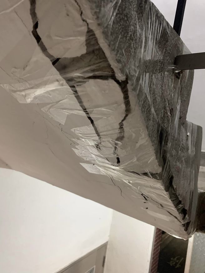 楼梯间裂痕非常大片，被邻居用胶带固定得密不透风。(翻摄自爆料公社)