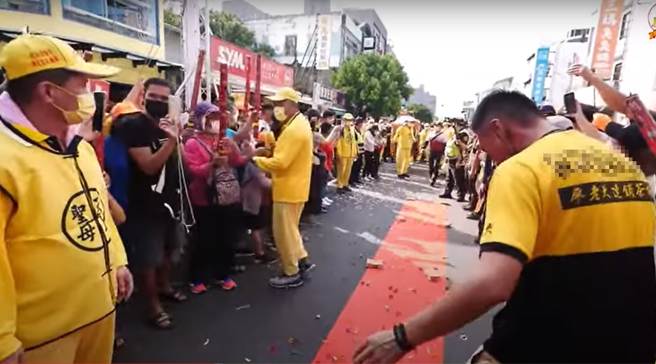 1名穿著廖老大飲料店制服男子站在鋪設的紅毯上，撂下一句「我就不相信，祢不會進來」。（翻攝自白沙屯拱天宮YouTube）