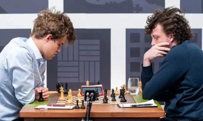 國際象棋辛克菲爾德盃第3輪比賽中，世界冠軍馬格努斯．卡爾森（左）爆冷門不敵新人19歲小將漢斯．尼曼（右）。賽後傳出尼曼可能用AI電子裝置作弊而獲勝。（圖／Saint Louis Chess Club）