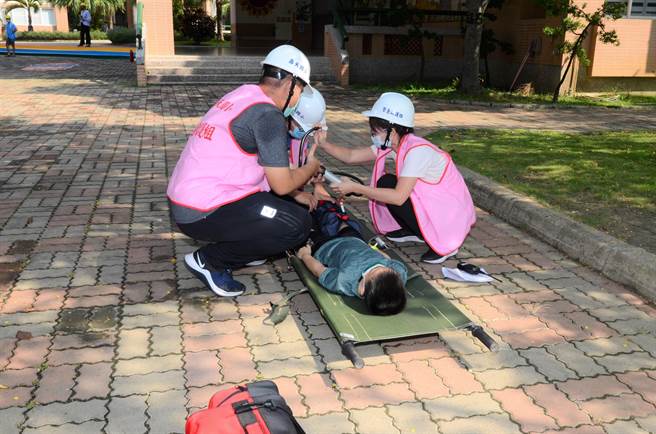 模拟芮氏规模4地震，高雄市冈山区寿天国小师生模拟伤者骨折的演练。（林瑞益摄）