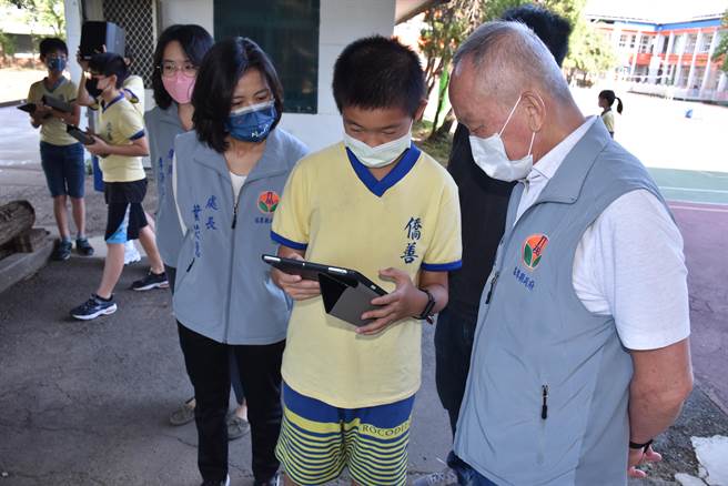 苗栗县长徐耀昌21日至侨善国小关心学童们使用平板电脑的情况，学童向徐耀昌示范解说使用。（谢明俊摄）