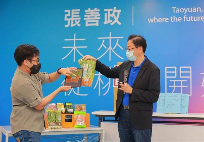 张善政当场拿出一包空心菜，示范刷二维条码查询产销履歷。(蔡依珍摄)