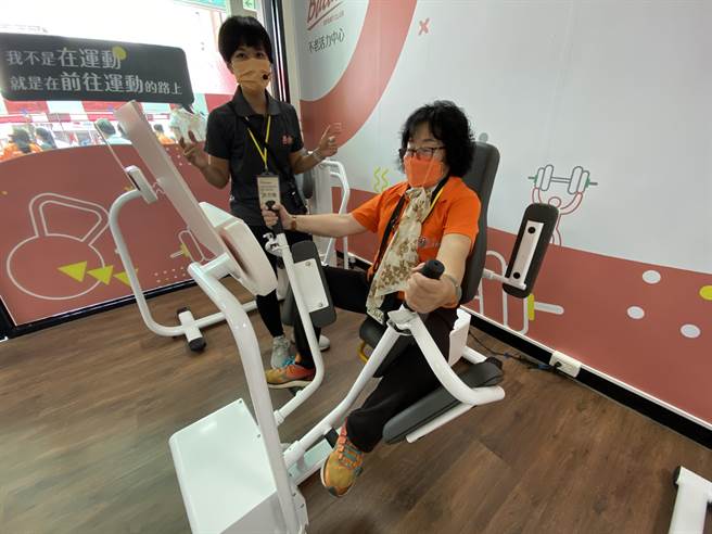 80多岁退休老师在运动指导员指导下使用智能健身器材训练肌力。（廖素慧摄）