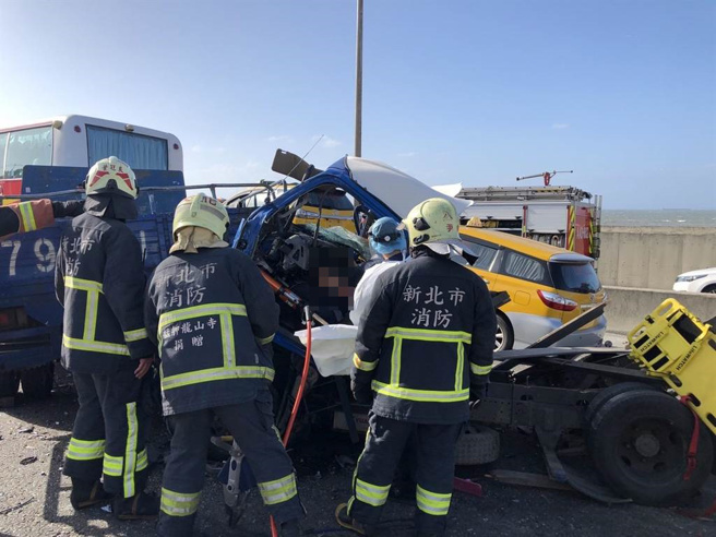 新北市台61线快速道路在21日下午发生一起连环车祸，造成2辆货车、1辆高公局吊车及1 辆游览车撞成一团，其中有2名驾驶一度受困在变形的车内，经抢救后已双双脱困，目前皆已送医急救中。(新北市消防局提供)