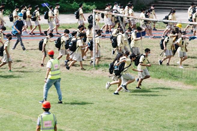 111年国家防灾日防空及震灾复合式灾害疏散避难演练，大直高中的学生在警报声响后，迅速前往安全避难地点集合。（郭吉铨摄）