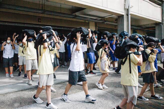 111年国家防灾日防空及震灾复合式灾害疏散避难演练，大直高中的学生在警报声响后，迅速前往安全避难地点集合。（郭吉铨摄）