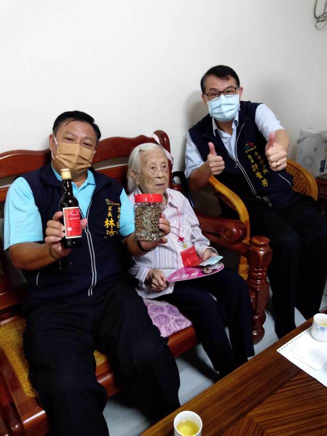 太平区103岁阿嬷黄掌莲（中）向上门送重阳礼金的区长许贵芳分享她每天睡前浅酌五加皮药酒配五个腰果养生秘方。（冯惠宜摄）