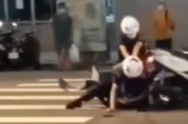 男骑士拒检遭男警压制在地，有民眾拍下过程，发现男警后方的女警神情相当慌张，不断把手压在男警背上，帮忙施加力道，还一度「骑到」男警背上。（翻摄自脸书「爆料公社公开版」）