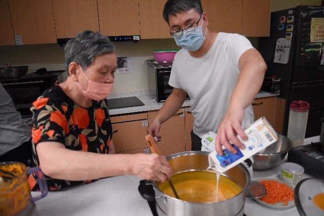王玠钧协助阿嬷烹煮南瓜浓汤。(照片/慈济科技大学提供)