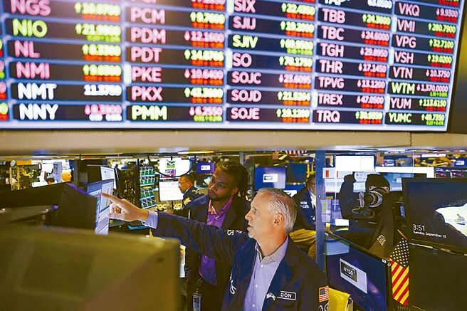 图为交易员在美国纽约证券交易所工作情形。（路透）