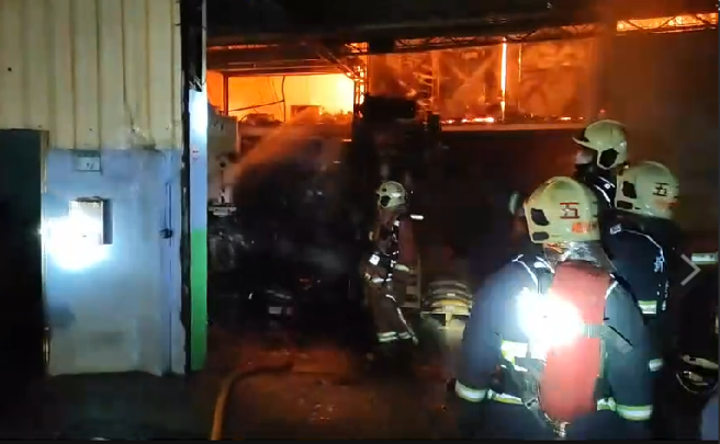 新北市新庄区思源路一处巷弄内今（23）晚7时许发生火警，该栋3层楼的工厂在2楼处窜出大量浓烟，火势随即延烧，火势在7点49分已获控制。（消防局提供）