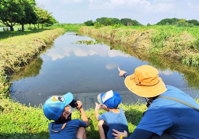 屏东环保局24日委由屏东县野鸟学会在海丰湿地举行生态探访赏鸟活动，在赏鸟专家指导下，小朋友拿着望远镜观察野鸟。（图/ 中央社）