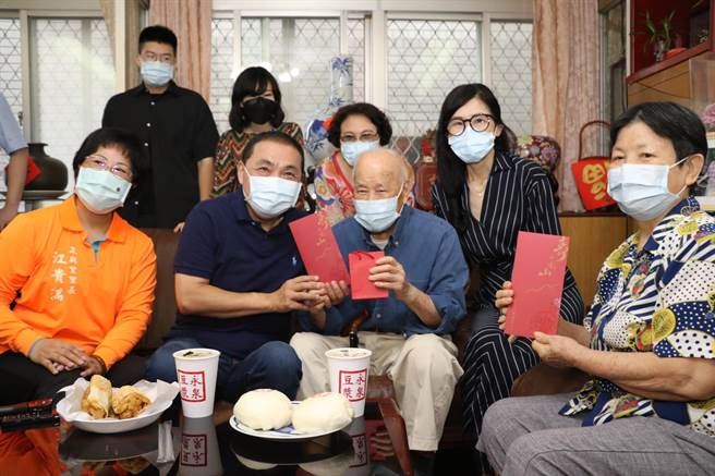 新北市长侯友宜致赠重阳礼金2万元给张子忠爷爷，右1为张奶奶，右2为小女儿张永华。（新北市社会局提供）