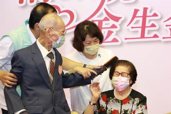 嘉义市今举办「情繫桃城，金生金世」金婚礼讚活动，邀请婚龄较长6对新人代表上台为另一半梳头。（嘉义市政府提供∕吕妍庭嘉义传真）