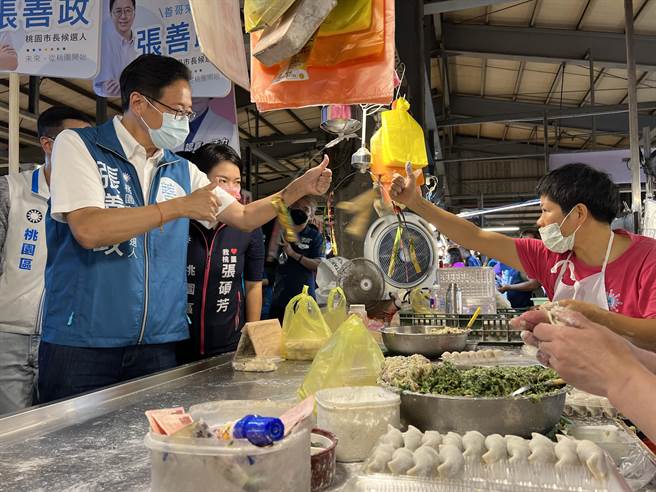 摊商比出大拇指对张善政比讚。(蔡依珍摄)