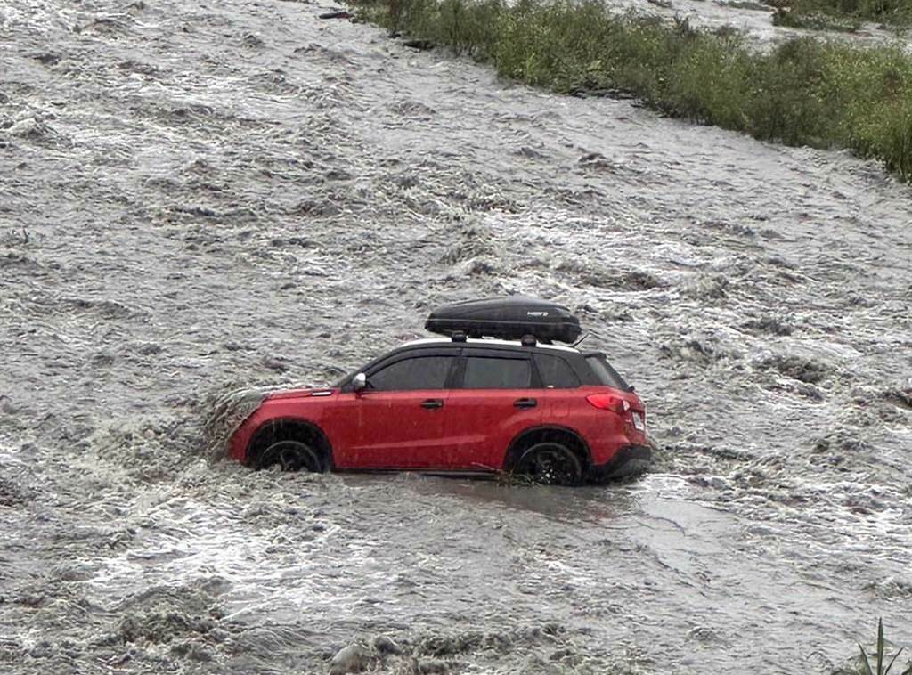 其中1輛紅色休旅車因停放溪床邊，遭溪流沖至河中央。（民眾提供／吳佩蓉宜蘭傳真）