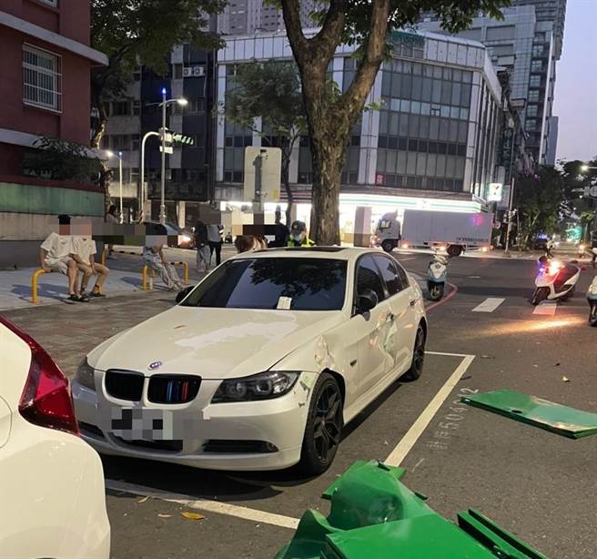 分隔岛上的灯号控制箱也遭撞飞，路边停放的白色BMW遭到灯号控制箱砸中。（高市苓雅分局提供／杨舒婷高雄传真）