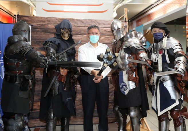 台北市长柯文哲（中）25日参观龙山文创基地，柯文哲拿起槌子与穿着骑士盔甲的摊位人员一起摆出帅气的姿势合影。（刘宗龙摄）