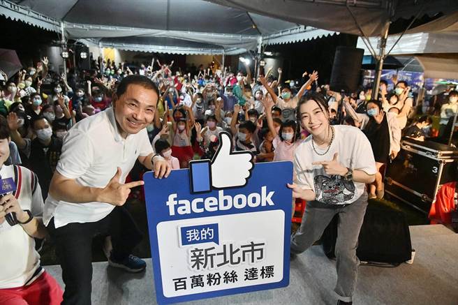 在Facebook拥有百万粉丝的街头鼓手罗小白，将象徵百万粉丝达标的里程碑交给新北市长侯友宜，庆祝我的新北市达成百万粉丝目标。（新北市新闻局提供）