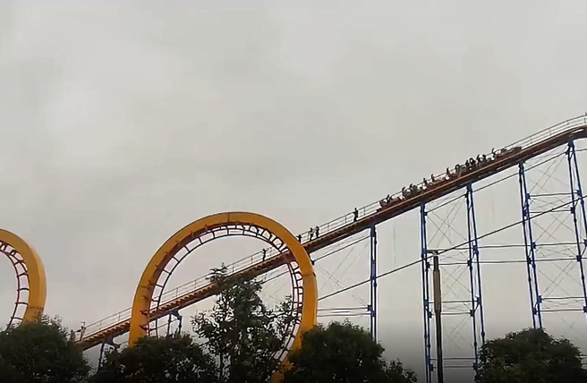 大陸河南省安陽市1處遊樂場雲霄飛車卡半空中，車上的乘客被迫走軌道下來到地面。（翻攝自微博）