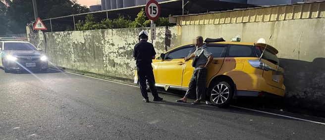 高雄市桥头区26日晚间发生一起抢案，一名嫌疑人拿美工刀抢夺计程车司机，司机将车辆靠在墙边。（民眾提供／林瑞益高雄传真）