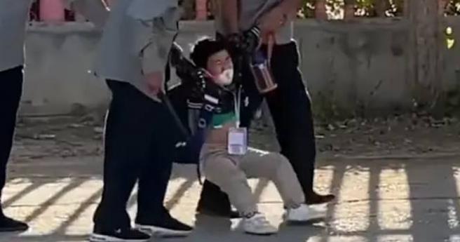 小学生不想上学，下秒遭架进校门。（图／翻摄自微博）