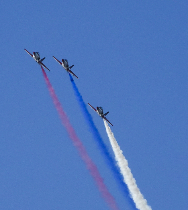 今年国庆空中分列式上午举行预演，三架空军AT-3喷出红、蓝、白三色烟雾飞越双北空域。（黄子明摄）