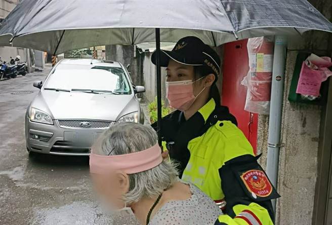 由於天候不佳，員警也耐心撐著傘，溫馨護送婦人返家。（警方提供／李奇叡新北傳真）