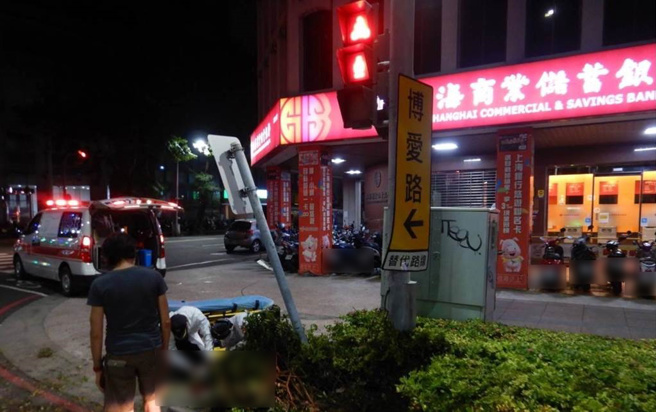 騎士自撞路旁標誌桿，救護人員到場後緊急將騎士送醫。（翻攝照片／高雄洪靖宜傳真）