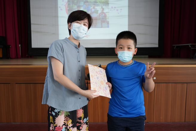 「猜猜我师谁？」猜中的同学与本尊合照，并拿小奖品。(照片/大桥国小提供)