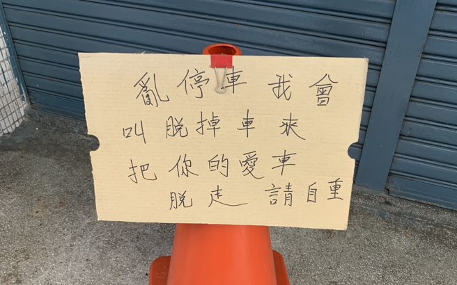 1名网友分享在路边发现的纸板，上头写着「乱停车我会叫脱（拖）吊车来，把你的爱车脱（拖）走，请自重」。（翻摄自脸书「路上观察学院」）