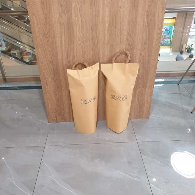 正妹在某商场发现「非常时尚」的灭火器罩，但她困惑「这样合法吗」。（翻摄自脸书路上观察学院）