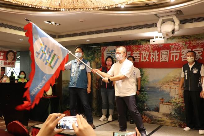 國民黨桃園市長參選人張善政贈戰旗，張善政桃園客家之友會長、前桃園縣長吳志揚揮舞戰旗。（蔡明亘攝）