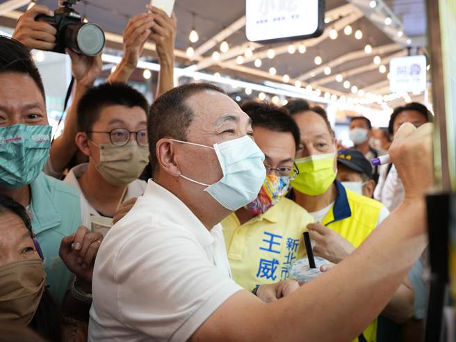 新北市长侯友宜(前排中)为摊贩招牌签名。(黄敬文摄)