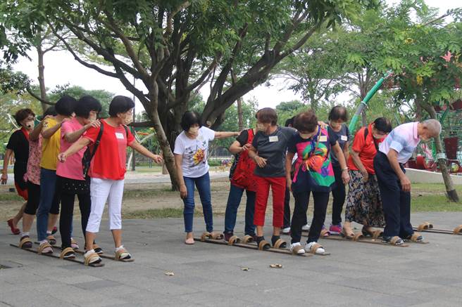 台中市社会局银向学习计画成果展，长辈体验穿木屐躜鲮鲤。（陈淑娥摄）