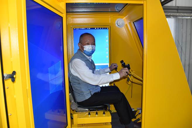 苗栗县长徐耀昌坐上起重机模拟器体验操作过程。（谢明俊摄）