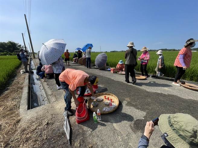 吉贝耍部落族人将饭菜摆放在农路旁遥祭祖灵。（李俊淇摄）