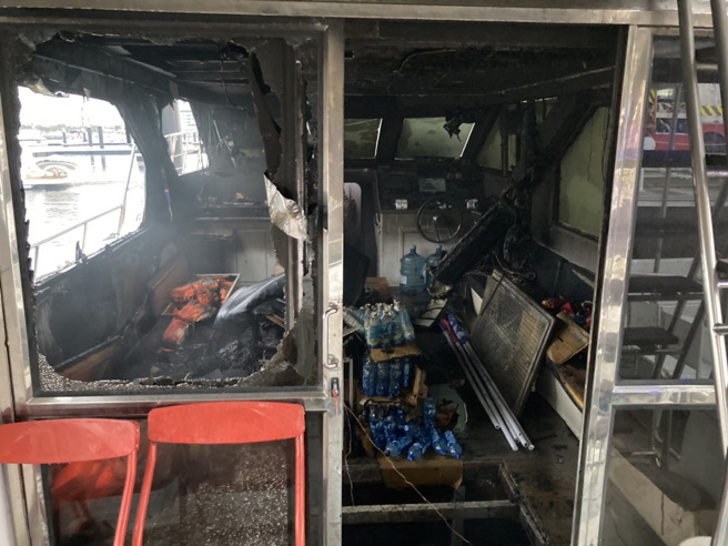 高雄1日下午停泊在光荣码头岸的千万游艇突然冒烟起火，民眾见状立即通报，警消获报后立即到现场扑灭，所幸无人伤亡，至于游艇起火原因仍待消防鑑识人员调查中。（翻摄照片／崔正纲高雄传真）
