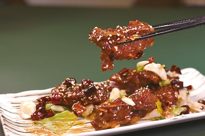 〈香辣吮指骨〉的猪小排先腌过再炸至外酥内嫩，然后再拌特制香辣酱汁成菜。图／姚舜