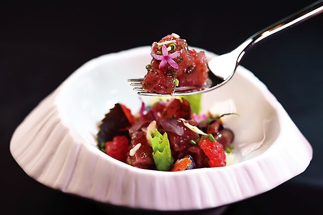 〈法式鲔鱼塔塔〉是以鲔鱼与樱桃番茄、草莓、西班牙腌渍甜椒（带甜味）、覆盆莓酱、食用花、蓝莓、紫苏(与杏仁碎片共拌，并以哈里萨辣酱（arissa）调味，呈盘色彩缤纷、味道甜咸共济、酸辣交织。图／姚舜