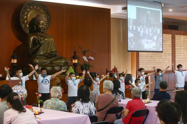 典礼中最为感人的地方，是由信眾的第二代与第三代联合表演，为阿公、阿嬷们祝贺。（邓博仁摄）