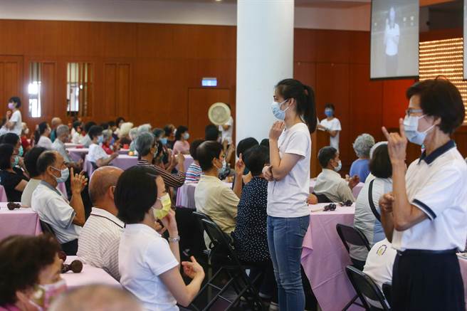 典礼中有《延命十句观音经》手语教唱，每位长者用心学习。（邓博仁摄）