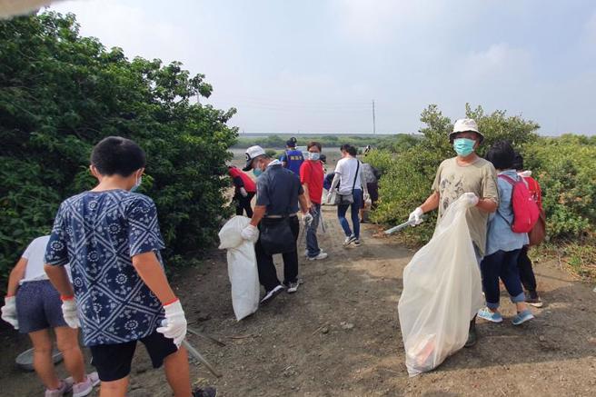 台南市生态保育学会2日号召近百人前往学甲溼地生态园区净滩，眾人朝急水溪北侧堤防方向前进，沿途捡拾人为垃圾，几小时就清出约120公斤废弃物。（图/ 中央社）