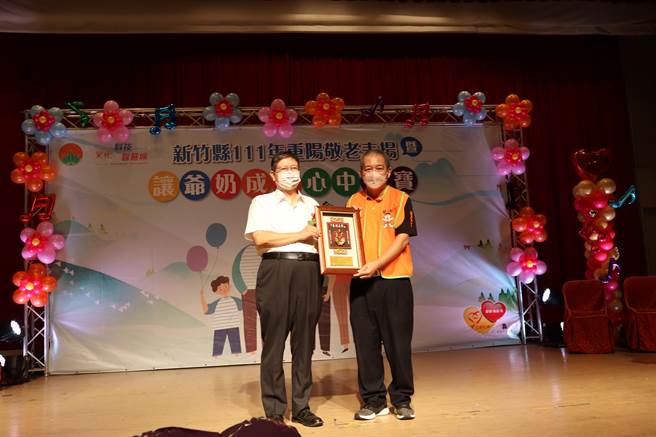 新竹县长杨文科（左）致赠感谢状予蔡衍明爱心基金会主任周哲仁。（邱立雅摄）